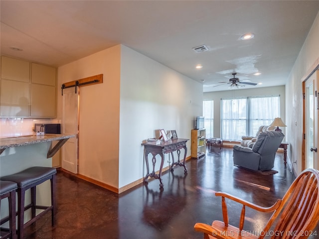 interior space featuring ceiling fan and a barn door