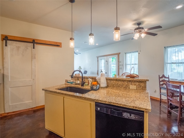 kitchen featuring dishwasher, a kitchen island with sink, sink, a barn door, and light stone counters