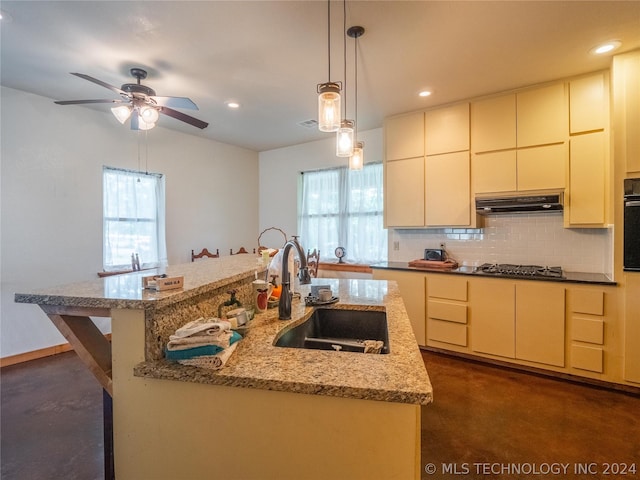 kitchen with a center island with sink, oven, plenty of natural light, and sink