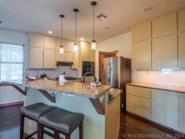 kitchen featuring a kitchen bar, light stone countertops, stainless steel appliances, and tasteful backsplash