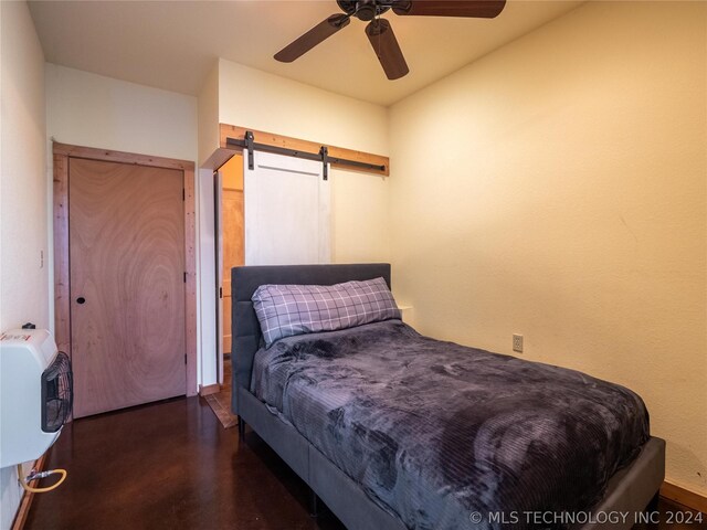 bedroom featuring a barn door, heating unit, and ceiling fan