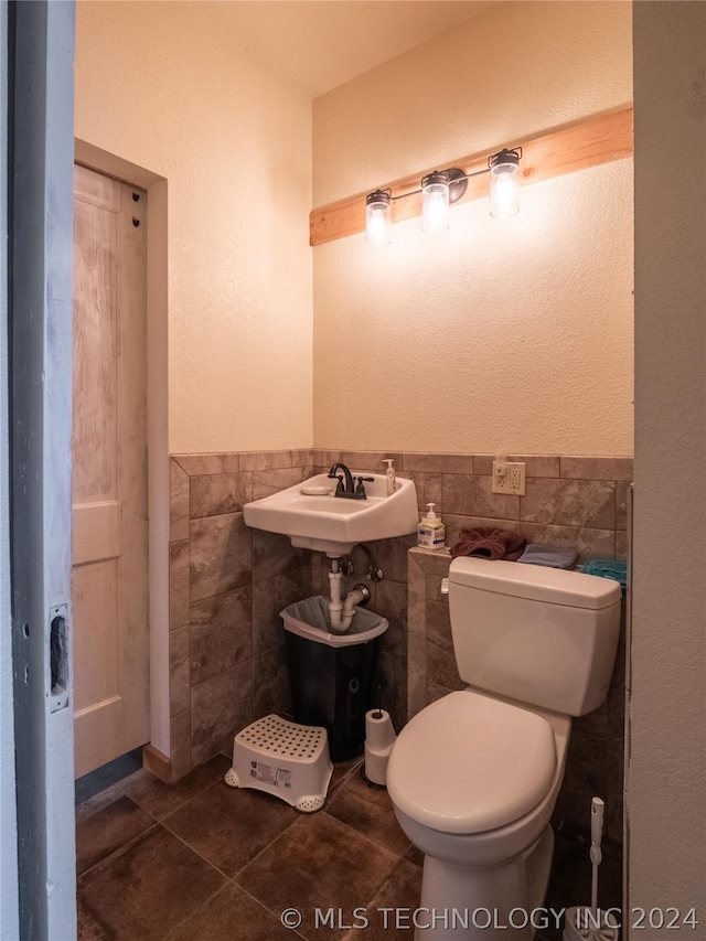 bathroom featuring tile patterned floors, tile walls, and toilet