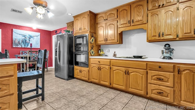 kitchen featuring light tile patterned flooring, ceiling fan, and black appliances