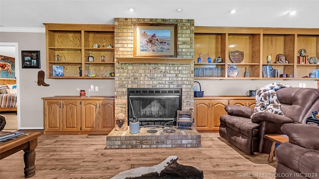 living room with a fireplace, light wood-type flooring, and ornamental molding