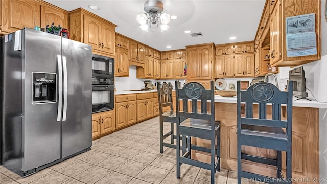 kitchen featuring light tile patterned floors, ceiling fan, and black appliances