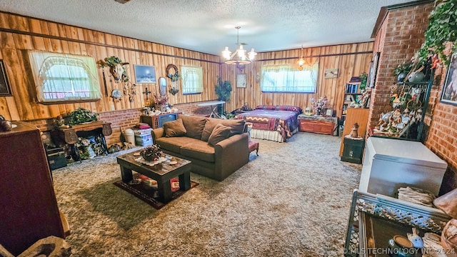 bedroom featuring carpet flooring, a textured ceiling, wooden walls, and a chandelier