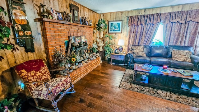 living room with a wood stove, wood walls, and hardwood / wood-style floors