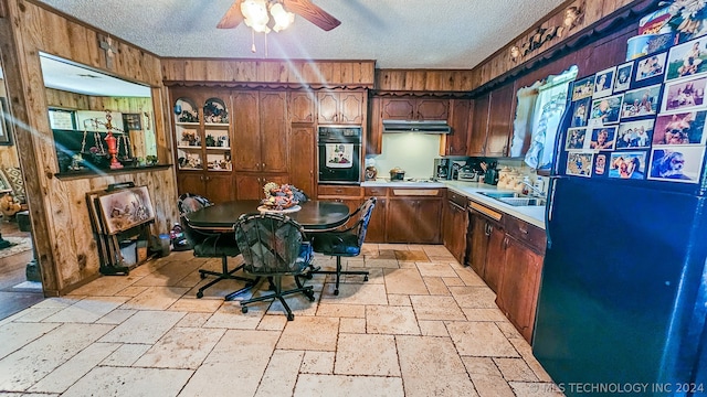 kitchen featuring a kitchen bar, a textured ceiling, sink, a center island, and oven