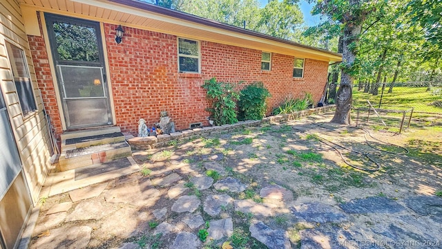 exterior space featuring brick siding and fence