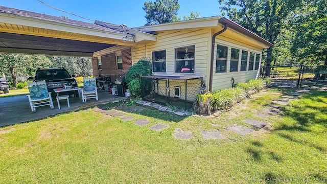 exterior space featuring a carport, a front lawn, and fence