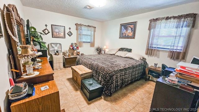 bedroom featuring light tile patterned floors and a textured ceiling