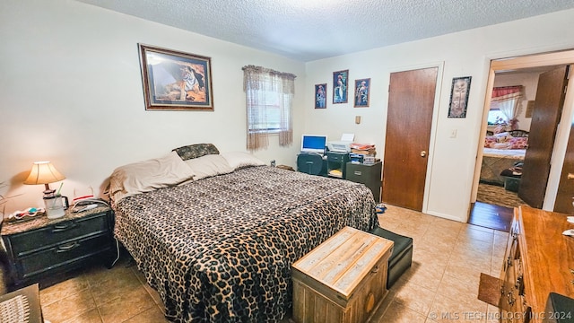 bedroom with light tile patterned floors, a textured ceiling, and a closet