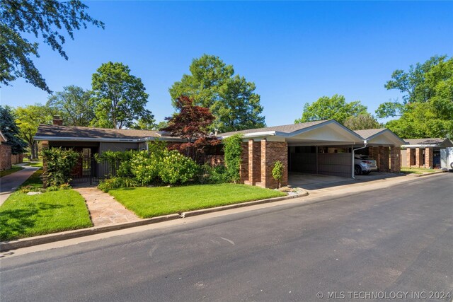 view of front of home featuring a front yard and a carport