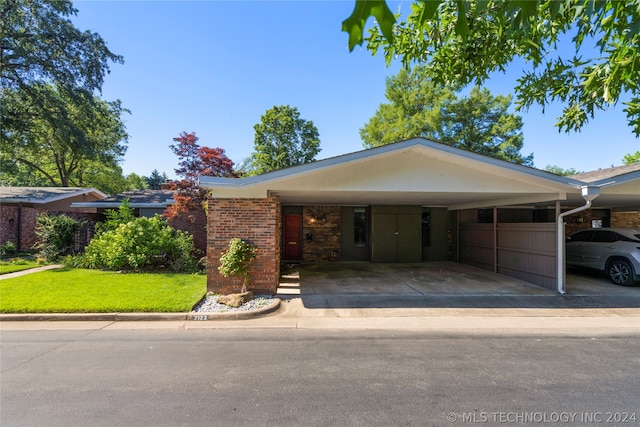 single story home featuring a front lawn and a carport