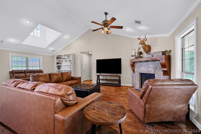 living room featuring ceiling fan, crown molding, wood-type flooring, a fireplace, and lofted ceiling