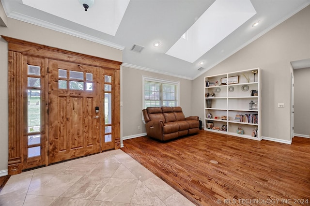 tiled foyer entrance featuring lofted ceiling with skylight and crown molding