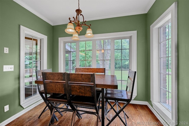 dining area featuring ornamental molding, a wealth of natural light, and a notable chandelier