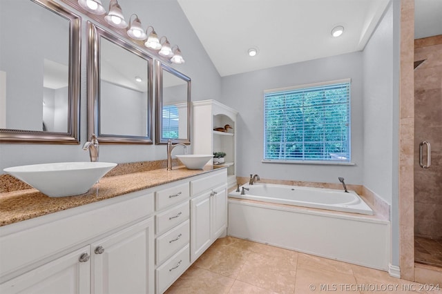 bathroom with tile patterned flooring, vanity, plus walk in shower, and vaulted ceiling