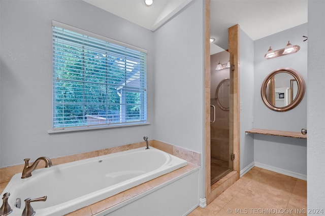 bathroom with tile patterned flooring, shower with separate bathtub, and lofted ceiling