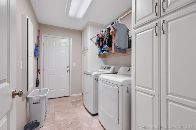 laundry area with cabinets, independent washer and dryer, and light tile patterned floors