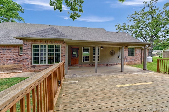 wooden terrace with ceiling fan and a patio area