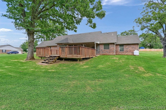 back of house with a deck and a lawn