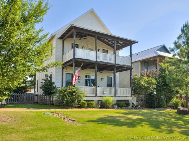 back of property featuring a yard, ceiling fan, a balcony, and covered porch