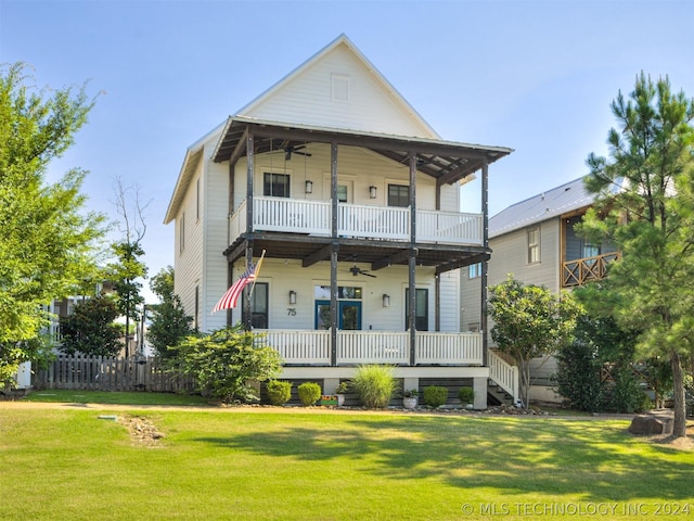 back of house featuring covered porch, a yard, a balcony, and ceiling fan