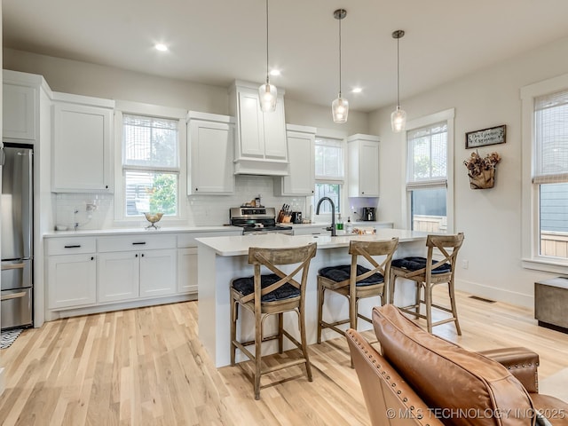 75 Lower Green Way, Carlton Landing, OK 74432 - kitchen featuring stainless steel appliances, light countertops, light wood-style floors, a kitchen bar, and recessed lighting