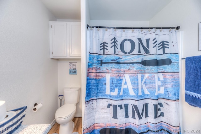 bathroom with toilet, a shower with shower curtain, and wood-type flooring