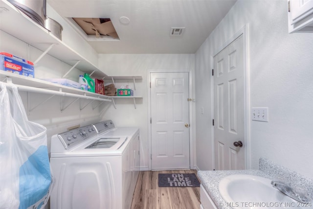 laundry area with washer and dryer and wood-type flooring