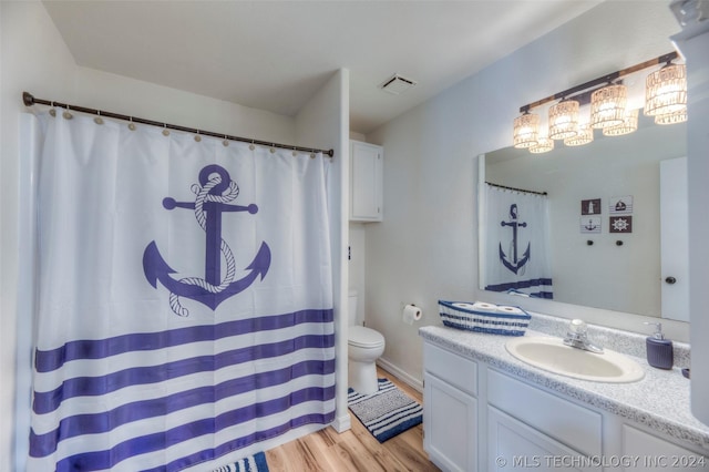 bathroom with hardwood / wood-style floors, toilet, and vanity