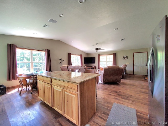 kitchen featuring plenty of natural light, ceiling fan, hardwood / wood-style flooring, and stainless steel refrigerator