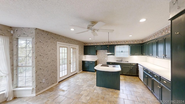 kitchen featuring french doors, a center island, a textured ceiling, dishwasher, and ceiling fan