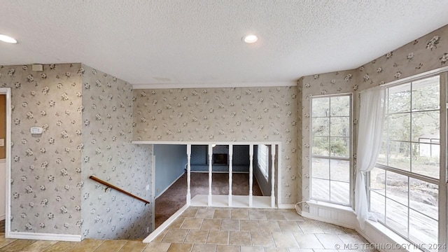 spare room featuring a healthy amount of sunlight and a textured ceiling