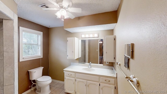 bathroom with vanity, ceiling fan, toilet, tile patterned floors, and a textured ceiling