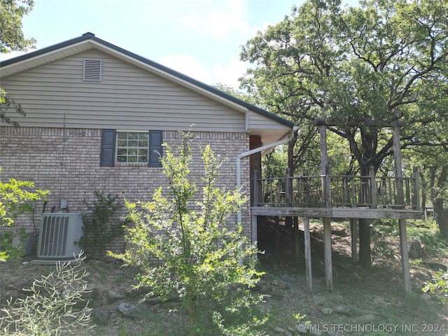 view of side of home with central AC and a deck