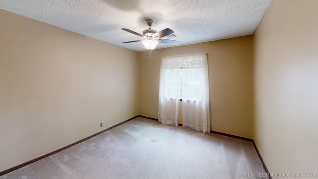 carpeted spare room with ceiling fan and a textured ceiling