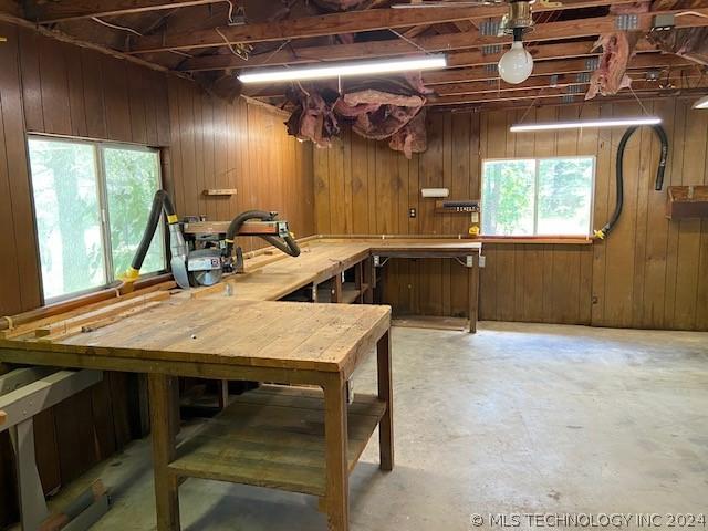 basement featuring wooden walls and a workshop area