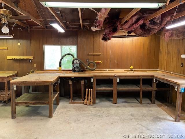 basement with a workshop area and wood walls