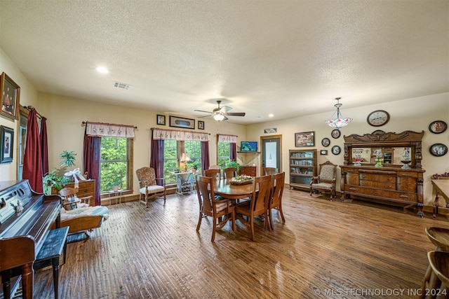 dining room featuring wood-type flooring, ceiling fan, and a textured ceiling