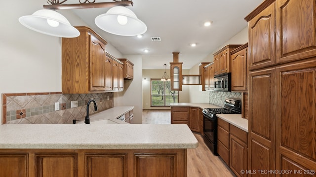 1805 College Park Rd, Claremore, OK 74017 - kitchen with gas stove, stainless steel microwave, a peninsula, light wood-style flooring, and tasteful backsplash