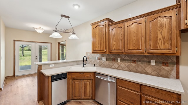 1805 College Park Rd, Claremore, OK 74017 - kitchen with stainless steel dishwasher, a sink, a peninsula, brown cabinets, and light wood-style floors