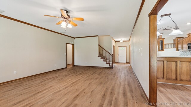1805 College Park Rd, Claremore, OK 74017 - unfurnished living room featuring ceiling fan, ornamental molding, light wood-type flooring, stairs, and baseboards