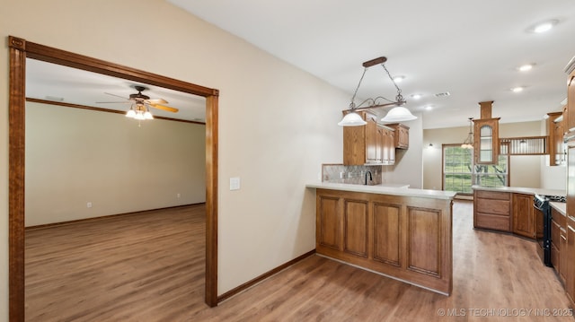 1805 College Park Rd, Claremore, OK 74017 - kitchen featuring a peninsula, gas stove, light wood-style floors, a ceiling fan, and light countertops