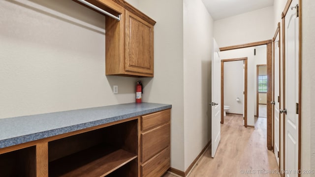 1805 College Park Rd, Claremore, OK 74017 - washroom featuring light wood-style flooring, a desk, and baseboards