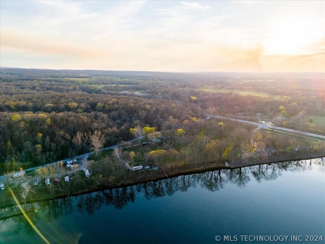 aerial view at dusk featuring a water view