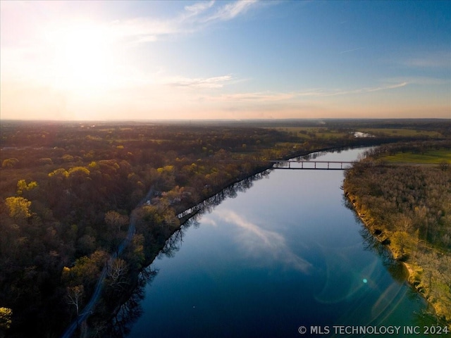 aerial view at dusk featuring a water view