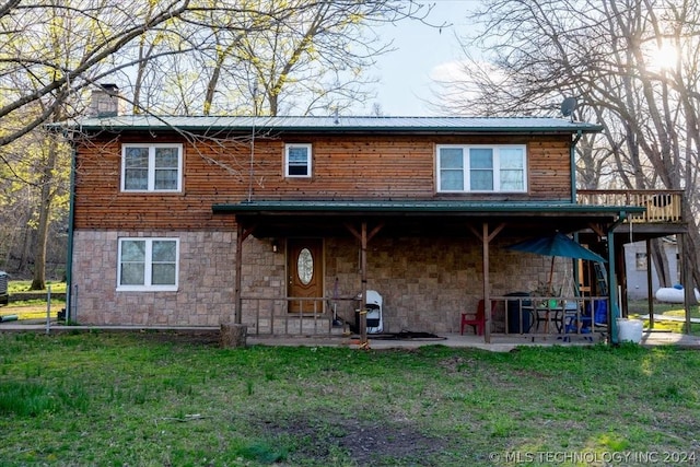 rear view of house featuring a yard and a patio area