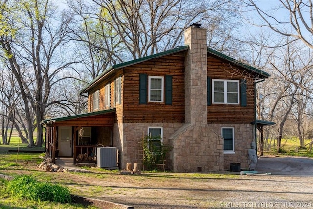 view of side of home with a porch and central AC